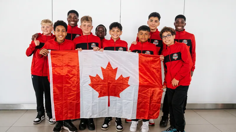 Équipe de l'Académie de soccer Révolution de Foot Vibe à Montréal-Est, en survêtement rouge et noir, tenant le drapeau du Canada avant un tournoi.